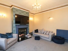 A living room with a television above a fireplace at Kingfisher House Saltburn-by-the-Sea