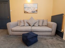 A living room with a sofa and cushions at Kingfisher House in Saltburn-by-the-Sea
