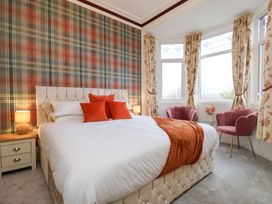 A bedroom with a bed and armchairs at Kingfisher House Saltburn-by-the-Sea