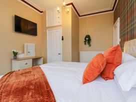 A bedroom with a bed, television, and a mirror at Kingfisher House in Saltburn-by-the-Sea