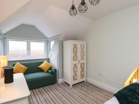 A bedroom with a sofa and wardrobe at Kingfisher House Saltburn-by-the-Sea