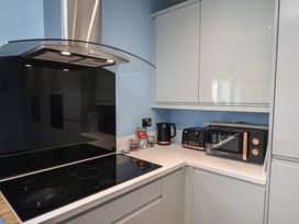 A kitchen with a stove and microwave at Kingfisher House in Staithes