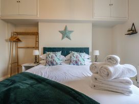 A bedroom with a bed and towels arranged at Kingfisher House in Staithes