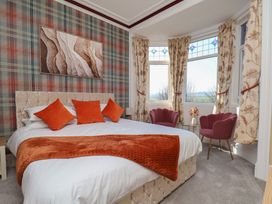 A bedroom with a bed and armchairs at Kingfisher House Staithes