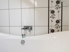 A bathroom with a bathtub and faucet at Kingfisher House in Staithes