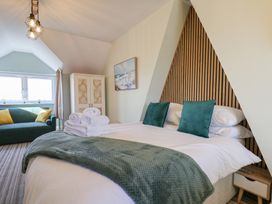 A bedroom with a bed and sofa at Kingfisher House in Staithes