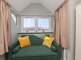 A snug with a sofa and windows at Kingfisher House in Staithes