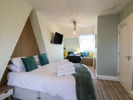 A bedroom with a bed and television at Kingfisher House in Staithes