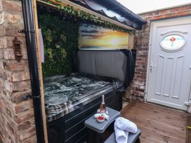 An outdoor area with a hot tub and a table at Kingfisher House in Staithes