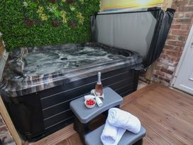 A hot tub with a bottle of champagne and strawberries at Kingfisher House in Staithes