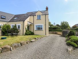 A yellow house with gravel driveway and garden furniture on grass at 5 Cart-Tws Bach in St Davids