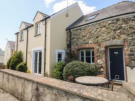 A stone and cream painted house exterior with outdoor table and chairs at 5 Cart-Tws Bach in St Davids
