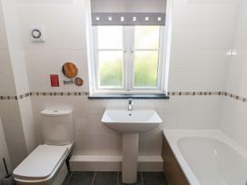 A bathroom with a toilet sink bathtub and a window at 5 Cart-Tws Bach in St Davids