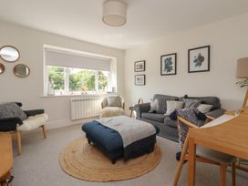 A living room with a sofa, chair, and an ottoman at St Gregory’s Cottage in Oswaldkirk near Helmsley