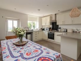 A kitchen with a dining table and modern appliances at St Gregory’s Cottage Oswaldkirk near Helmsley