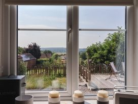A window view with candles and a garden outside at St Gregory’s Cottage, Oswaldkirk near Helmsley