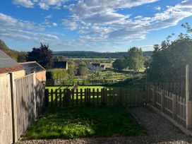 A garden with a fence and view of trees at St Gregory’s Cottage Oswaldkirk near Helmsley
