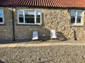 An outdoor area with two chairs and a small table at St Gregory’s Cottage in Oswaldkirk near Helmsley