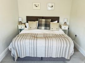 A bedroom with a bed and nightstands at St Gregory’s Cottage in Oswaldkirk near Helmsley