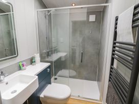 A bathroom with a sink toilet shower and towel rack at Elmside Lodge in Welland Malvern