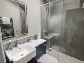 A bathroom with a sink countertop shower enclosure and a towel rack at Elmside Lodge in Welland Malvern