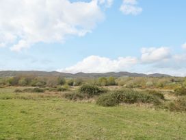 A grassy field with bushes and trees with hills in the background at Elmside Lodge in Welland Malvern