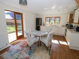 A kitchen with a round dining table set for four and floral upholstered chairs at Little Barn in Dodwell near Stratford-Upon-Avon