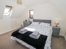 A bedroom with a double bed flanked by two bedside tables with lamps at Little Barn Dodwell near Stratford-Upon-Avon
