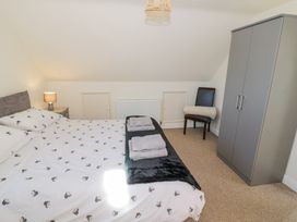 A bedroom with a bed folded towels on the bed and a wardrobe at Little Barn in Dodwell near Stratford Upon Avon