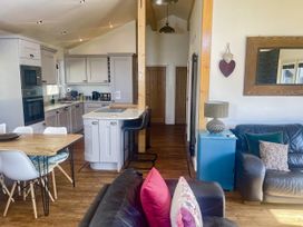 A kitchen with a table and chairs and a sofa at Woodburn Lodge in Otterburn