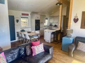 A kitchen and dining area with a table and chairs at Woodburn Lodge Otterburn
