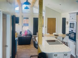 A kitchen with a dining area and a sofa at Woodburn Lodge in Otterburn