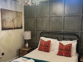 A bedroom with a bed and nightstand at Woodburn Lodge in Otterburn