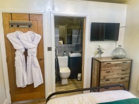 A bedroom with a bathroom and furniture at Woodburn Lodge, Otterburn