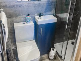 A bathroom with a toilet, sink, and shower at Woodburn Lodge in Otterburn