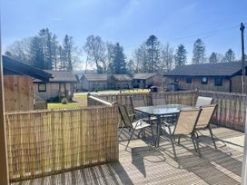 An outdoor area with a table and chairs at Woodburn Lodge in Otterburn