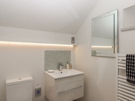 A small bathroom with a toilet sink with mirror above and a towel rack at Puddaven Barn in North Bovey near Chagford