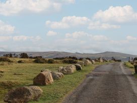 A country road with large rocks along the sides and hills in the background at Puddaven Barn in North Bovey near Chagford