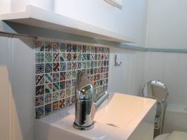 A bathroom sink with a chrome faucet and multicolored backsplash tiles at Songbirds in St Michaels Kent