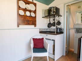A kitchen area with shelves and appliances at Songbirds in St Michaels, Kent