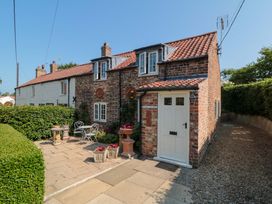 A cottage exterior with a garden seating area at Spring Cottage in York
