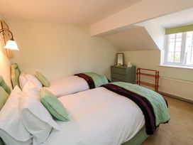 A bedroom with two beds, a mirror and a window at Spring Cottage in York