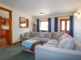 A living room with a sofa and windows at The Wedge in Mitchell near Summercourt