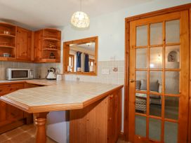 A kitchen with wood cabinets and appliances at The Wedge in Mitchell near Summercourt