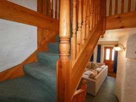 A staircase with wooden handrail and sofa visible at The Wedge in Mitchell near Summercourt