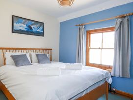 A bedroom with a bed and window at The Wedge in Mitchell near Summercourt