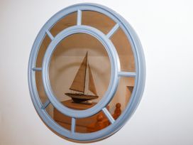 A mirror reflecting a model boat on a table at The Wedge in Mitchell near Summercourt