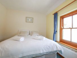 A bedroom with a bed and window at The Wedge in Mitchell near Summercourt