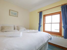 A bedroom with a bed and window at The Wedge in Mitchell near Summercourt