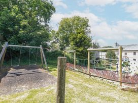 A swingset and climbing frame in an outdoor play area at The Wedge in Mitchell near Summercourt